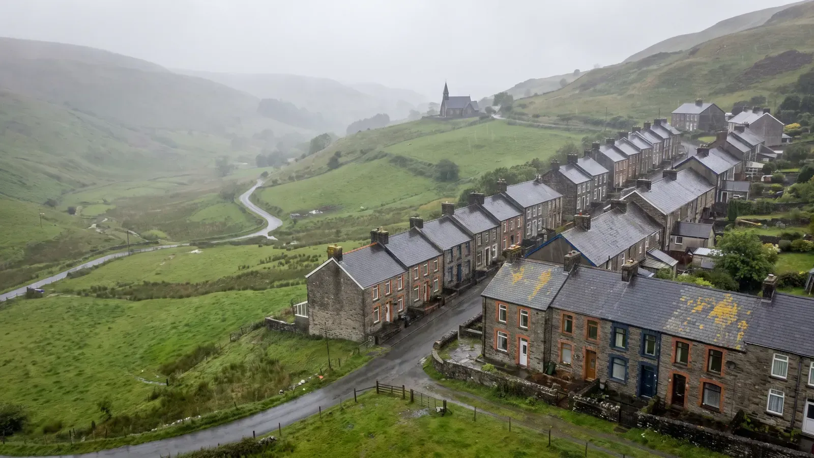 Stone terraced houses climbing a Welsh valley, typical homes for insulation grants in Wales